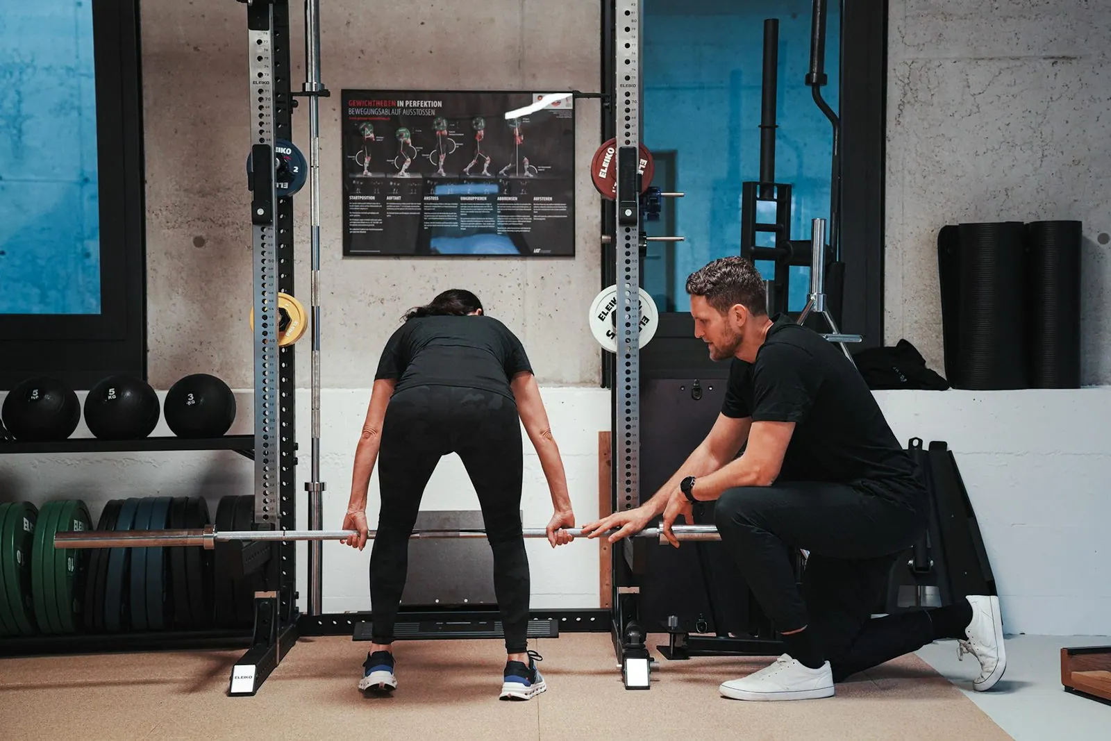 Krafttraining in Heidelberg: Trainer korrigiert die Kreuzheben-Technik an der Langhantel im BRIKS Studio